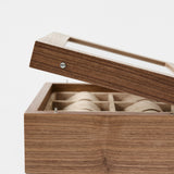 The TAWBURY Grove 6 Slot Wooden Watch Box in Light Walnut features a glass lid and multiple compartments—an elegant storage solution for watch enthusiasts.