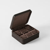 The TAWBURY Fraser 6 Watch Case in Espresso Brown is a dark leather box with a zipper, featuring six cushioned slots to securely hold and display your watches.