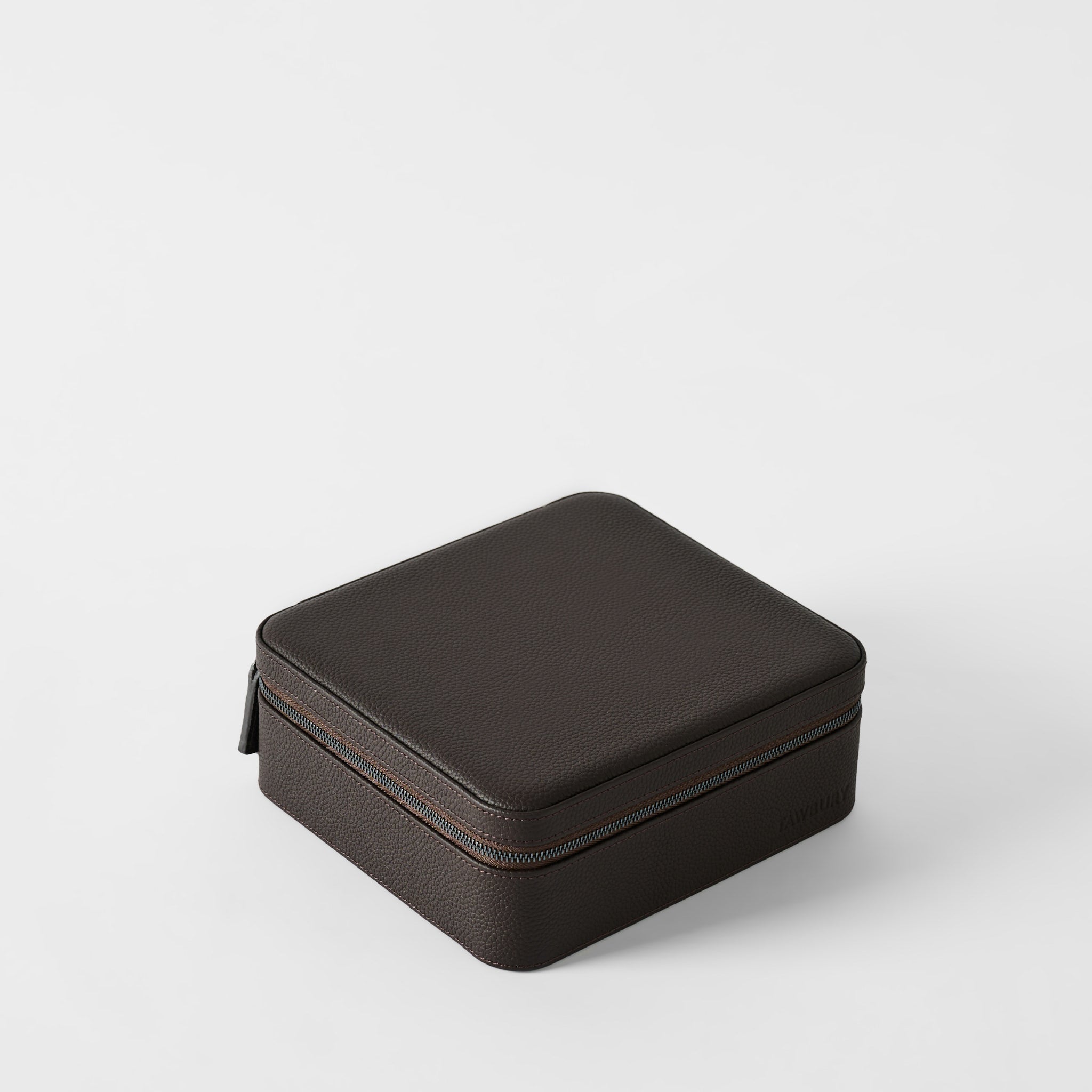 The TAWBURY Fraser 6 Watch Case in espresso brown leather features a square, textured design with a zipper, securely storing up to 6 watches. Shown closed on a plain white background.