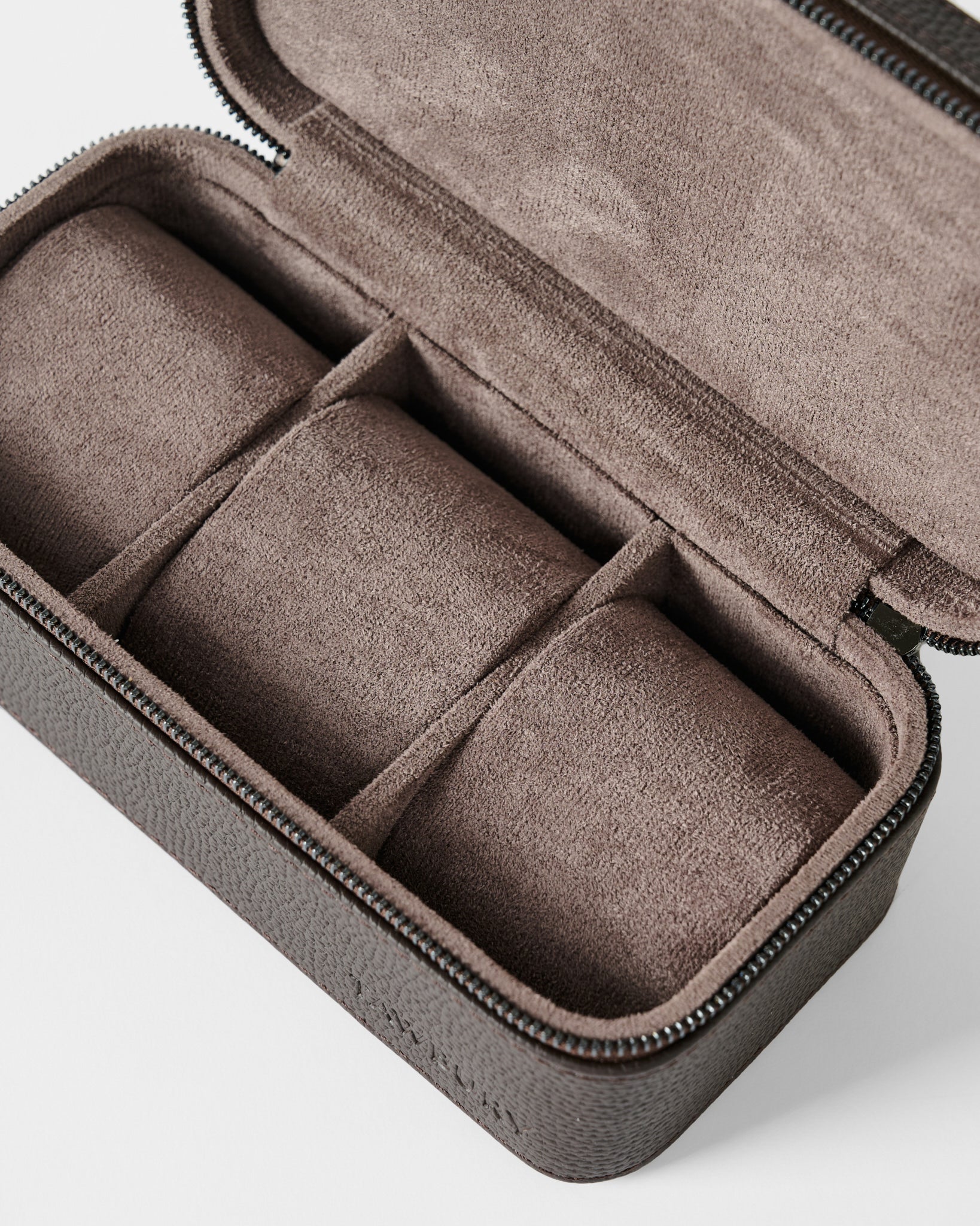 The TAWBURY Fraser 3 Watch Case - Brown is a rectangular leather travel case with a zipper and three compartments, each featuring a cushioned roll, perfect for organizing and protecting your watches on the go.