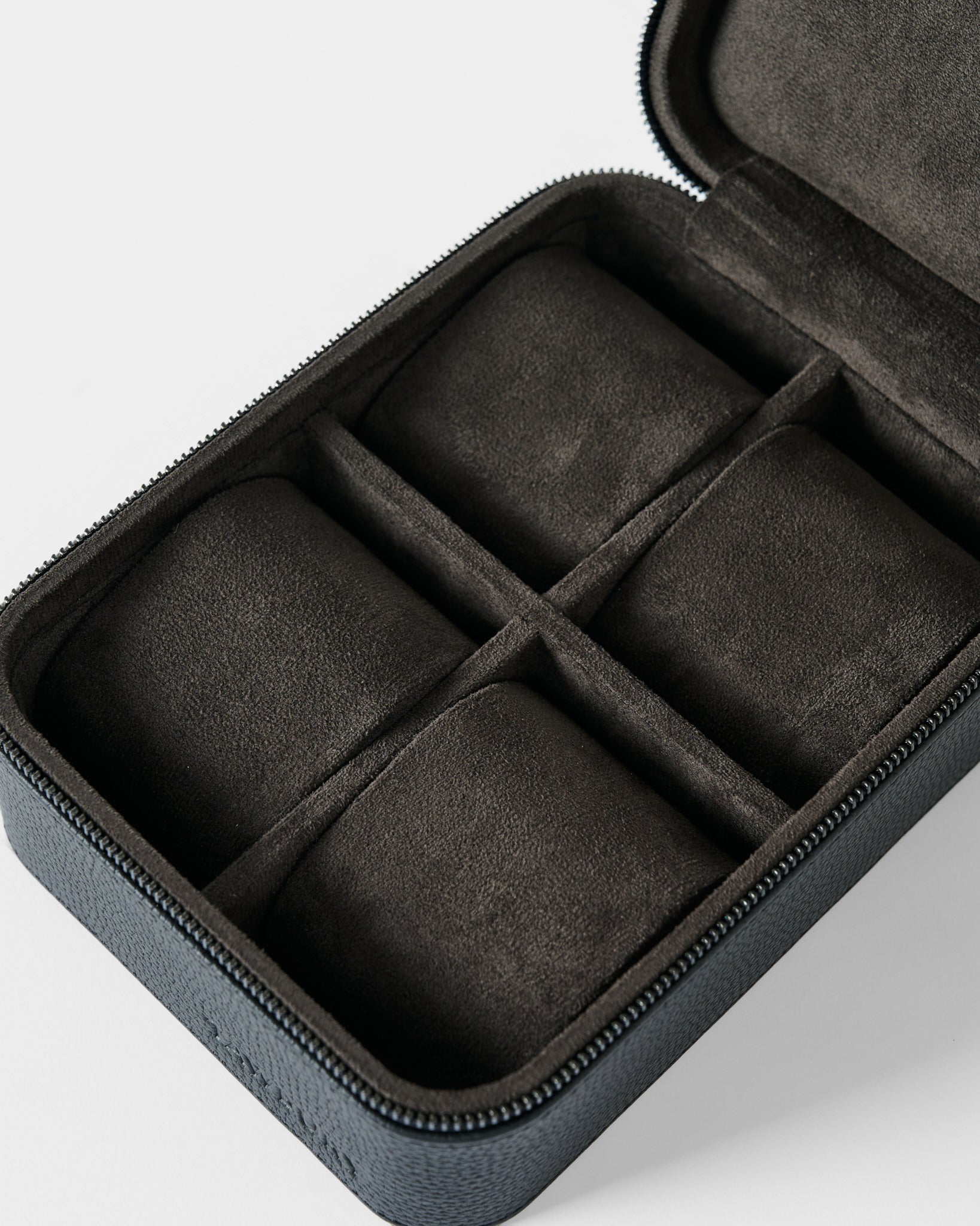 The TAWBURY Fraser 4 Watch Case - Black features four soft, suede-like padded compartments and a zippered leather exterior, designed to securely store and protect your watches or small accessories.