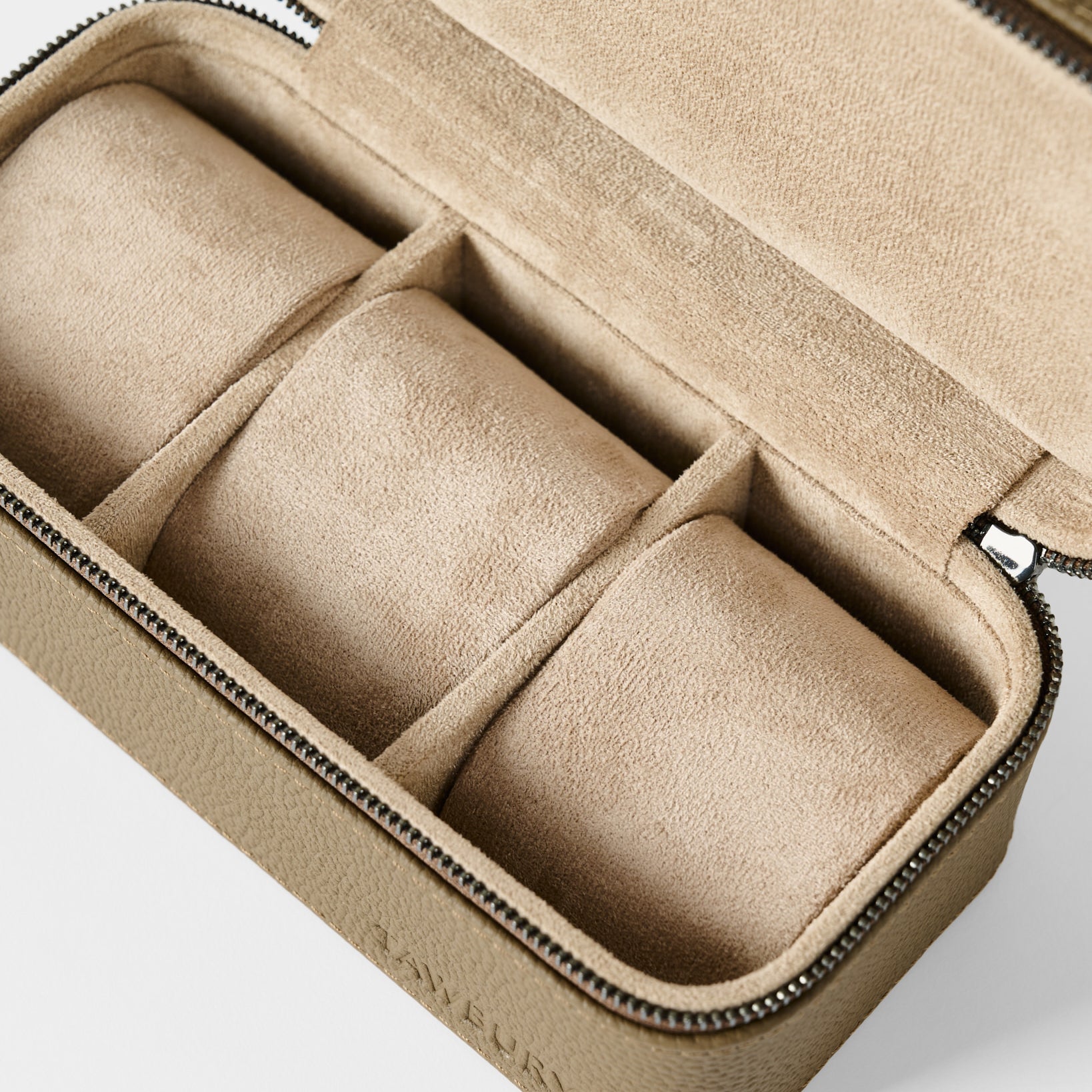 The TAWBURY Fraser 3 Watch Case in taupe is a rectangular leather travel case with a zip closure, beige suede interior, and three padded sections for organizing your watches.