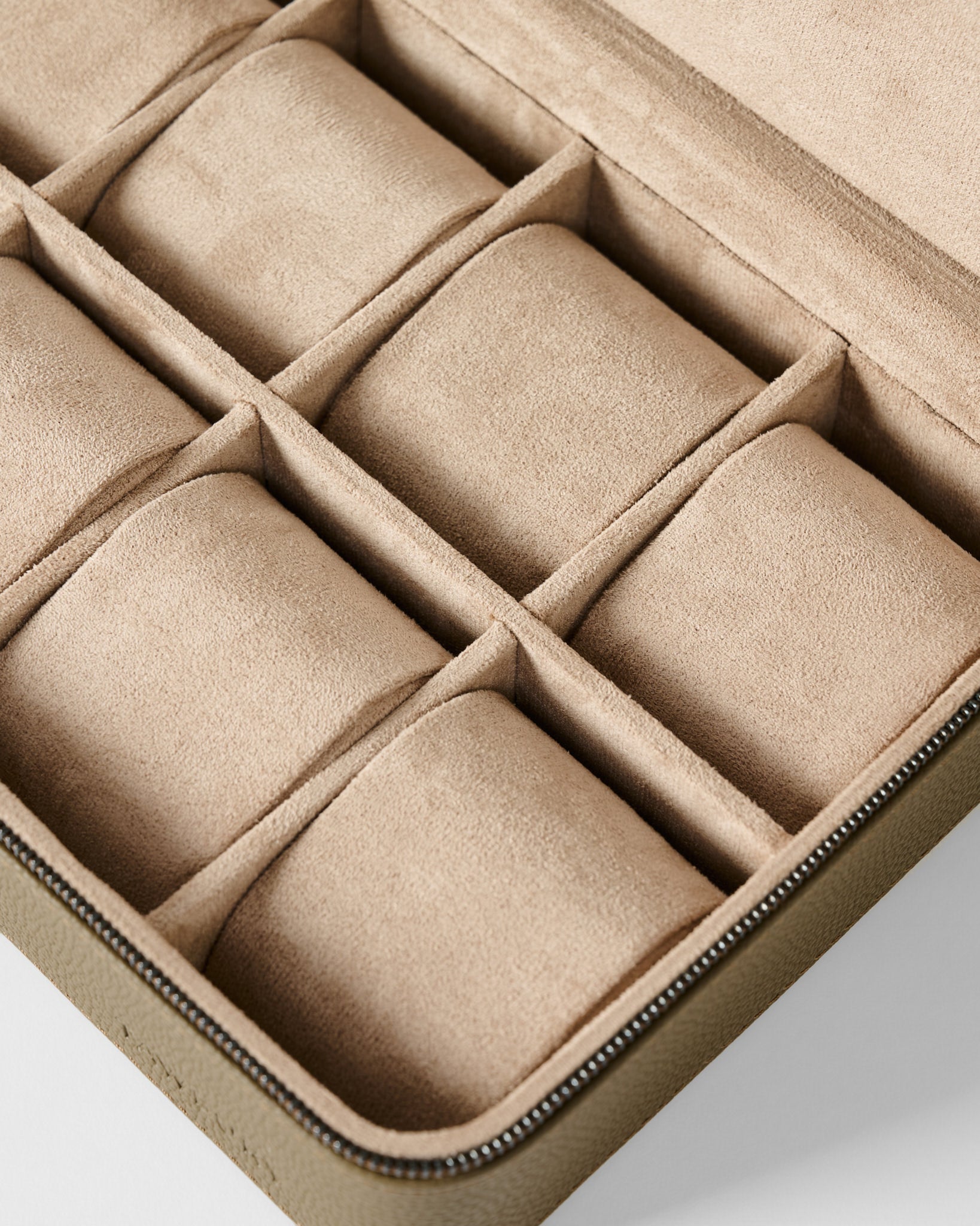 The TAWBURY Fraser 8 Watch Case in taupe features a beige suede-lined interior, eight compartments, and a zippered closure, shown here in an overhead view.