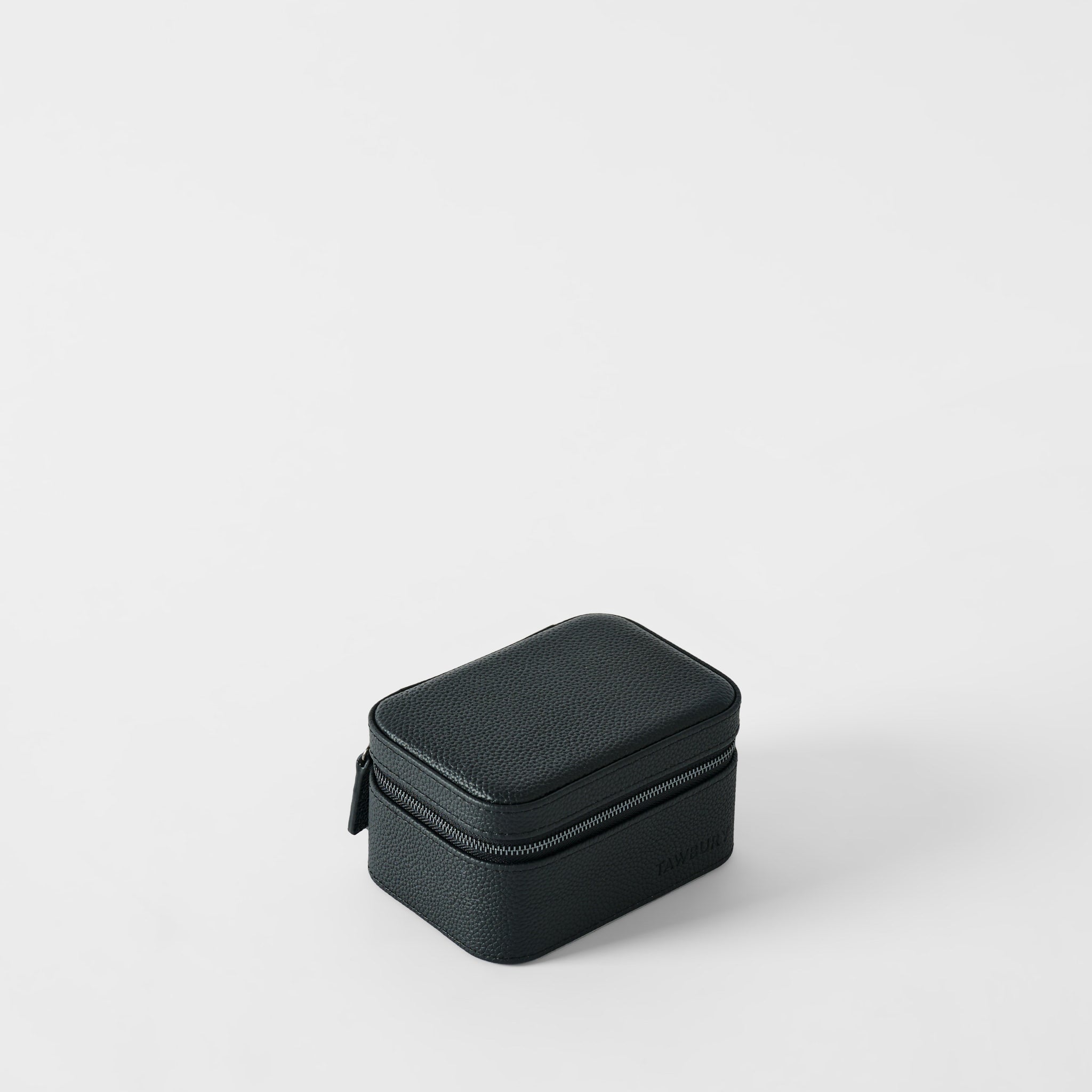 The TAWBURY Fraser 2 Watch Case in Midnight Black, a compact rectangular case made of textured material with a zipper, rests on a plain white surface.