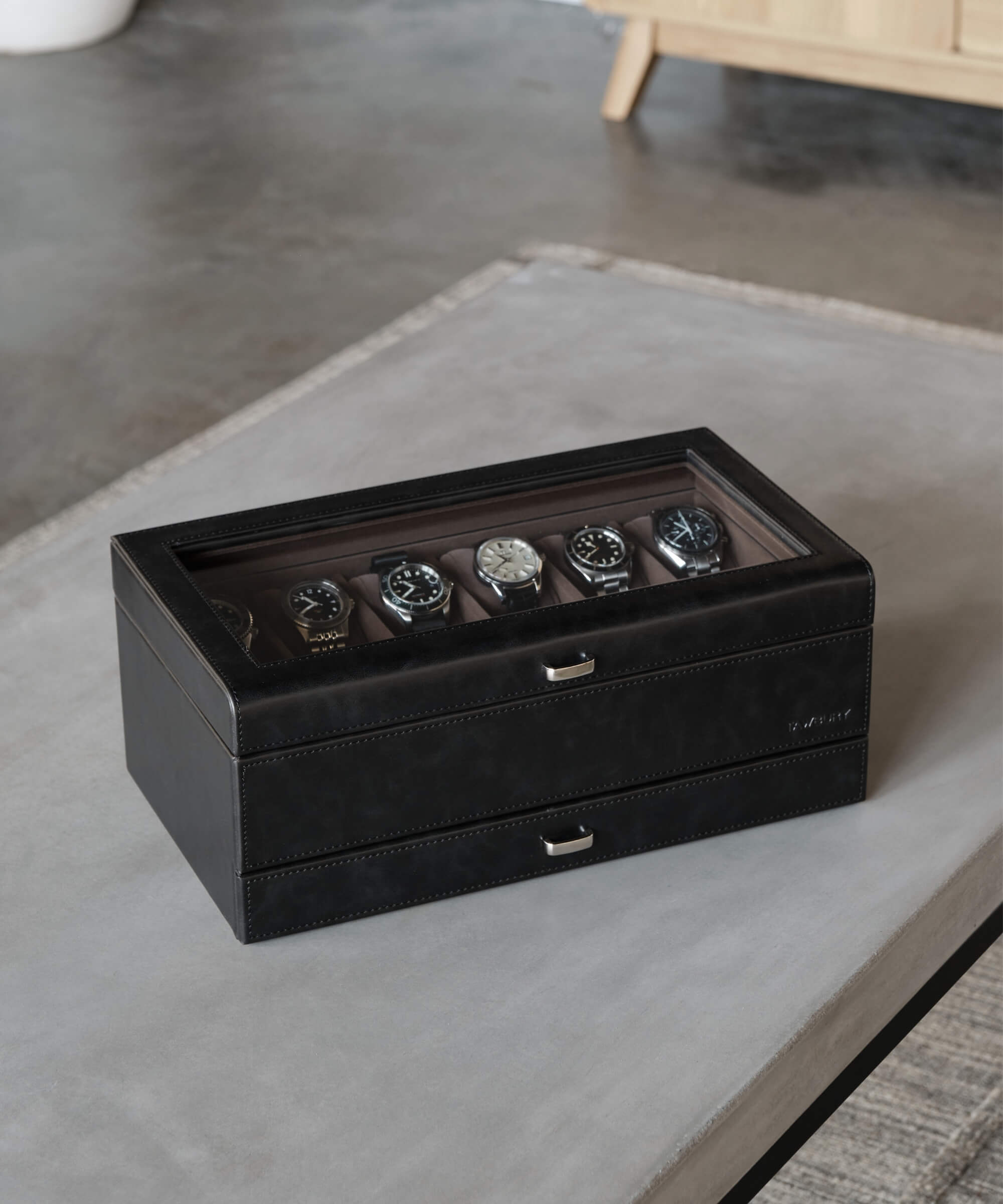 A sleek TAWBURY Bayswater 12 Slot Watch Box with Drawer - Black on top of a table.
