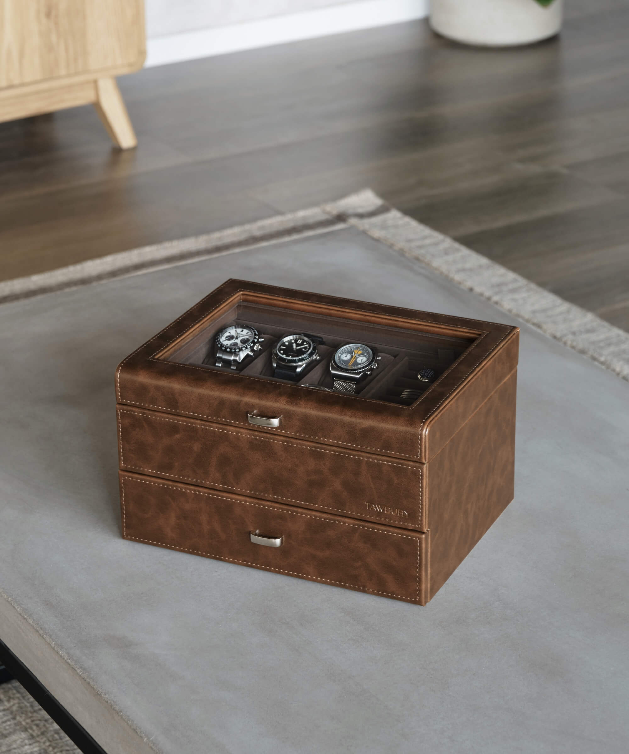 A TAWBURY Bayswater 6 Watch Jewellery Box - Brown, made of vegan leather, sitting on a table in a living room.