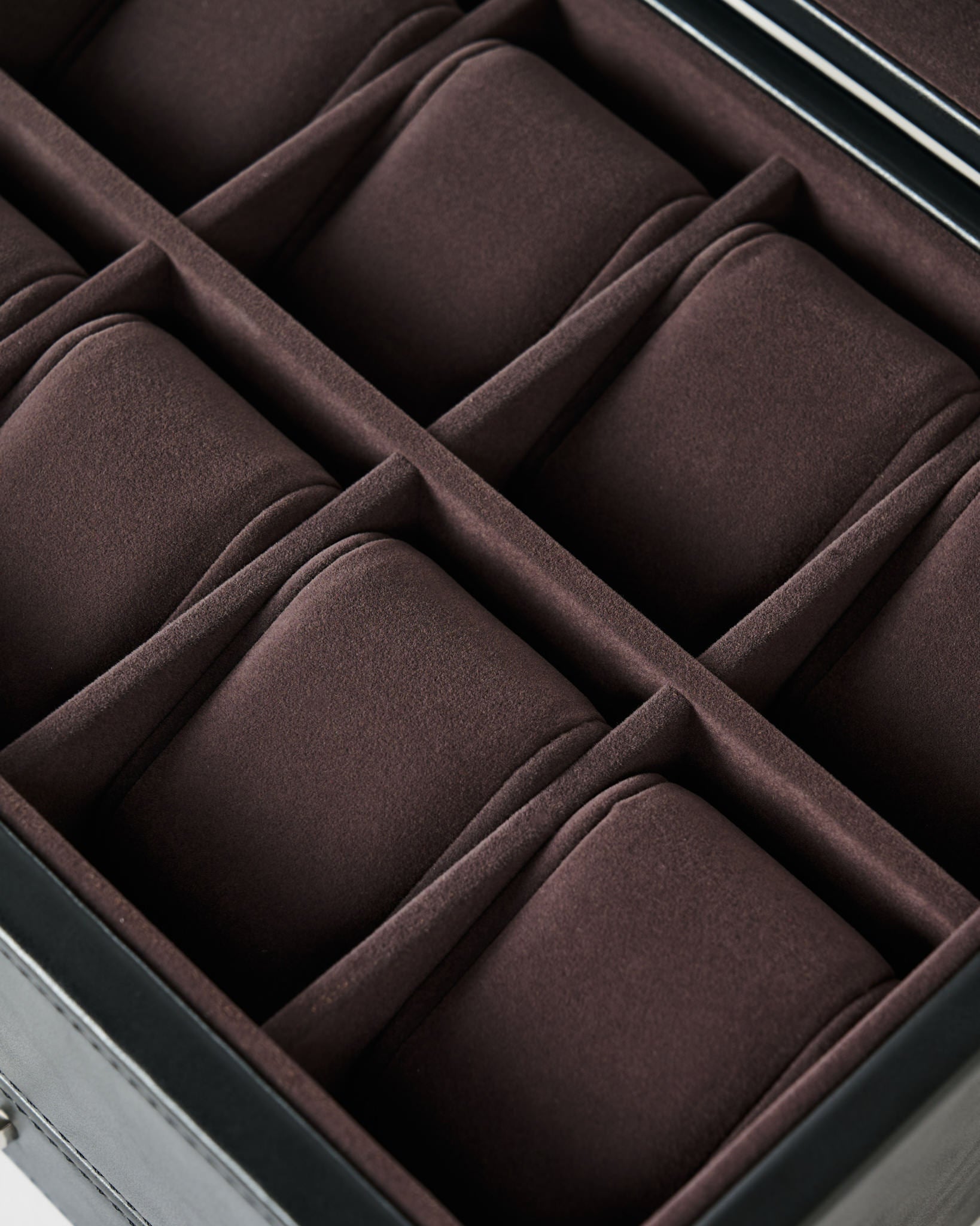 A close-up of the TAWBURY Bayswater 8 Slot Watch Box with Storage in Black/Charcoal, featuring velvet-lined, padded compartments arranged in two rows.