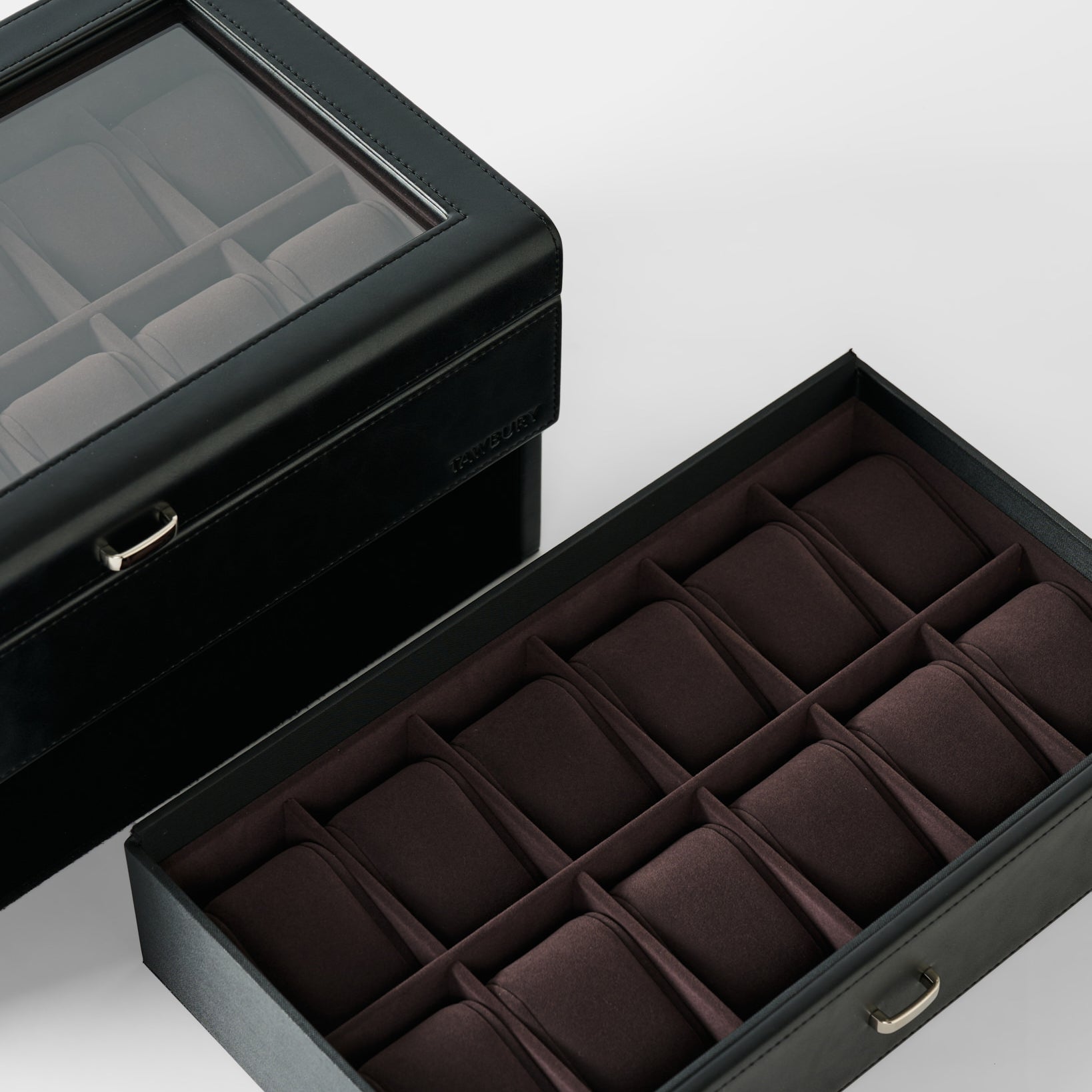 The TAWBURY Bayswater 24 Slot Watch Box with Drawer in Black/Charcoal features a glass lid and open drawer, both revealing multiple padded compartments for stylish watch storage and display.
