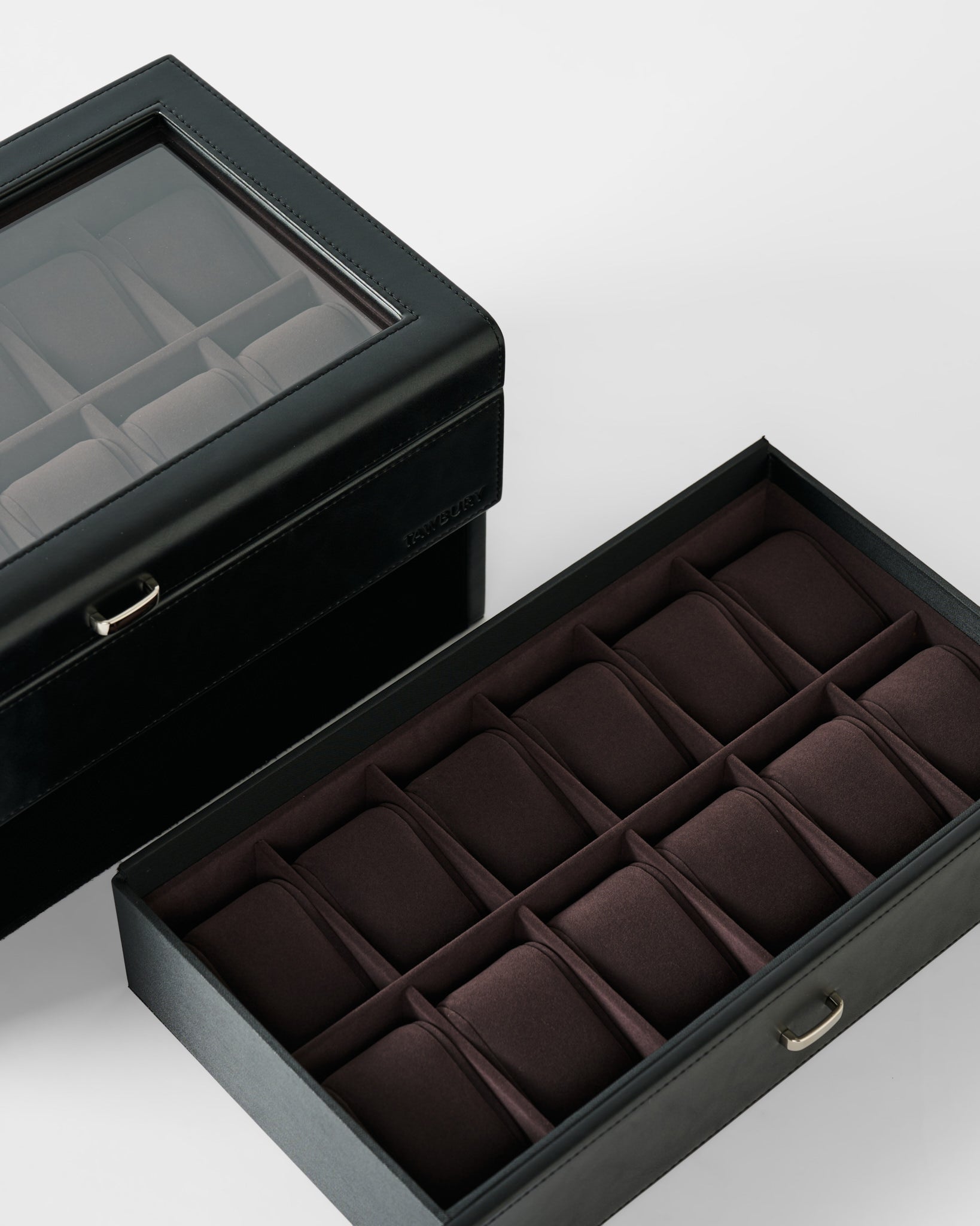 The TAWBURY Bayswater 24 Slot Watch Box with Drawer in Black/Charcoal features a glass lid and open drawer, both revealing multiple padded compartments for stylish watch storage and display.