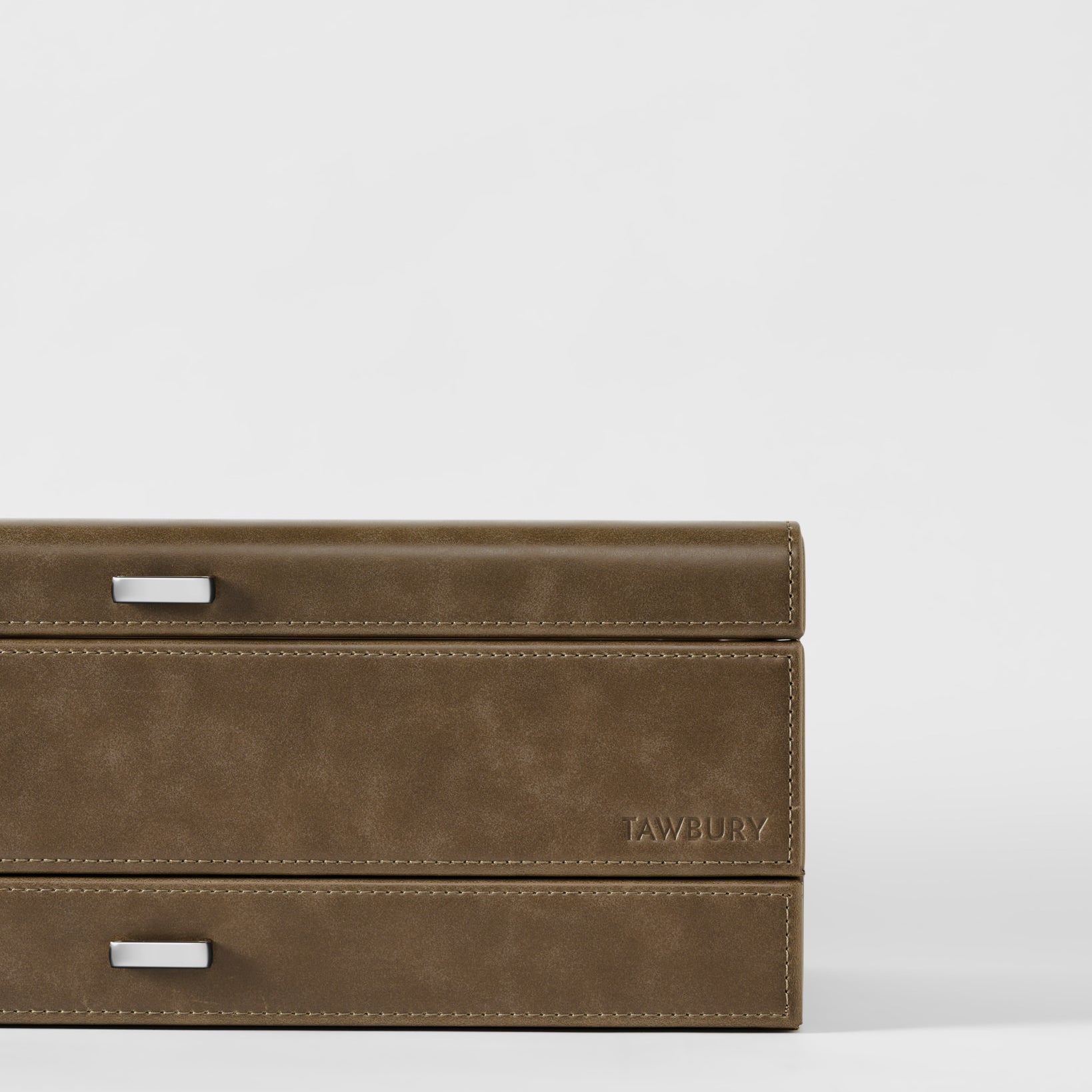 The TAWBURY Bayswater 12 Slot Watch Box with Storage in taupe features two drawers, metal handles, and the embossed brand name on the lower right corner.
