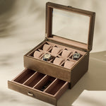 The TAWBURY Bayswater 8 Slot Watch Box with Storage in taupe features a glass lid, pillows for two watches, multiple empty compartments, and a lower drawer for extra watch storage.
