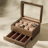 The TAWBURY Bayswater 8 Slot Watch Box with Storage in taupe features a glass lid, pillows for two watches, multiple empty compartments, and a lower drawer for extra watch storage.