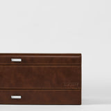 A close-up of the TAWBURY Bayswater 12 Slot Watch Box with Storage in brown, featuring silver rectangular handles and "TAWBURY" embossed on the lower right corner—ideal for elegant watch organization.
