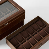 The TAWBURY Bayswater 24 Slot Watch Box with Drawer in brown features a glass lid and multiple cushioned compartments—ideal for organizing and displaying your collection.