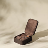 The TAWBURY Fraser 4 Watch Case - Brown features four compartments and brown suede lining, shown open with a watch inside—ideal for keeping your timepieces organized and protected at home or while traveling.