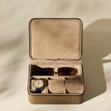 The TAWBURY Fraser 3 Watch Case with Storage in taupe displays a wristwatch and sunglasses in its compartments, showcased in soft natural light.