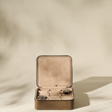 The TAWBURY Fraser 6 Watch Case in taupe, shown open with two watches inside and two empty compartments, offers a stylish storage solution for your collection against a neutral backdrop.