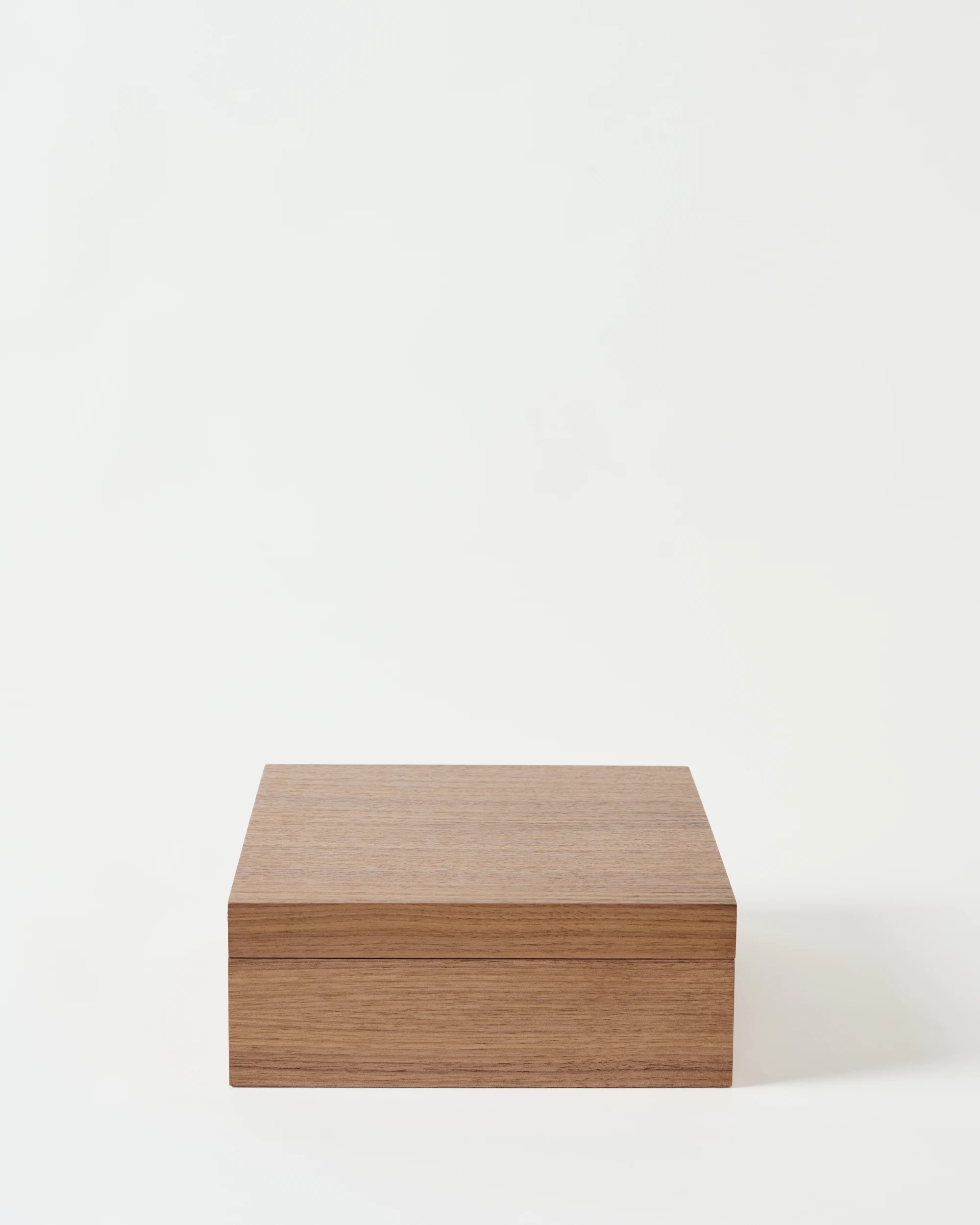 The TAWBURY Grove 12 Slot Wooden Watch Box features a solid lid, light walnut wood, and a smooth finish, showcased against a white background.