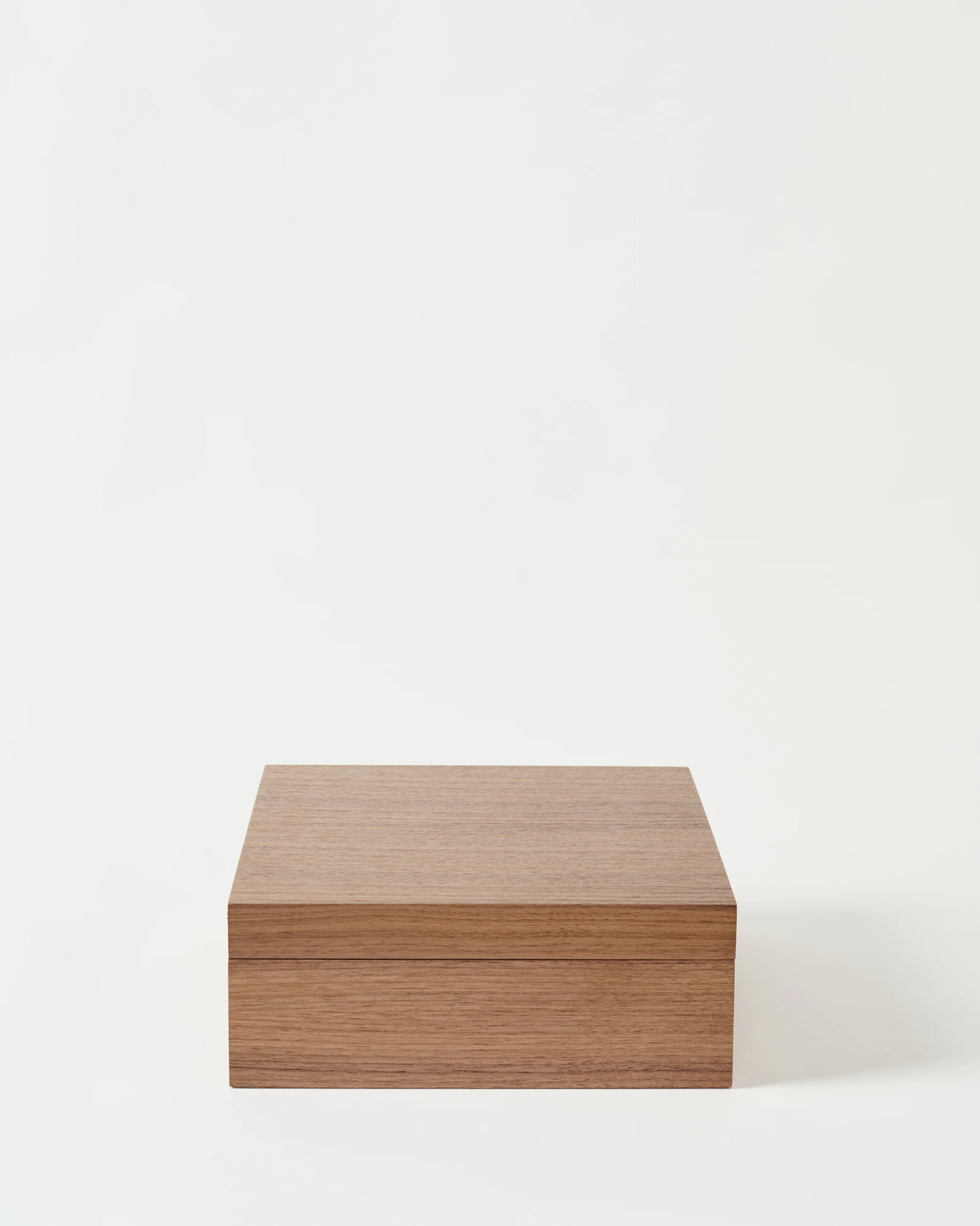 The TAWBURY Grove 12 Slot Wooden Watch Box features a solid lid, light walnut wood, and a smooth finish, showcased against a white background.