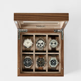 A must-have for watch lovers, the TAWBURY Grove 6 Slot Wooden Watch Box in Light Walnut features a glass lid and six compartments to stylishly display your wristwatch collection.