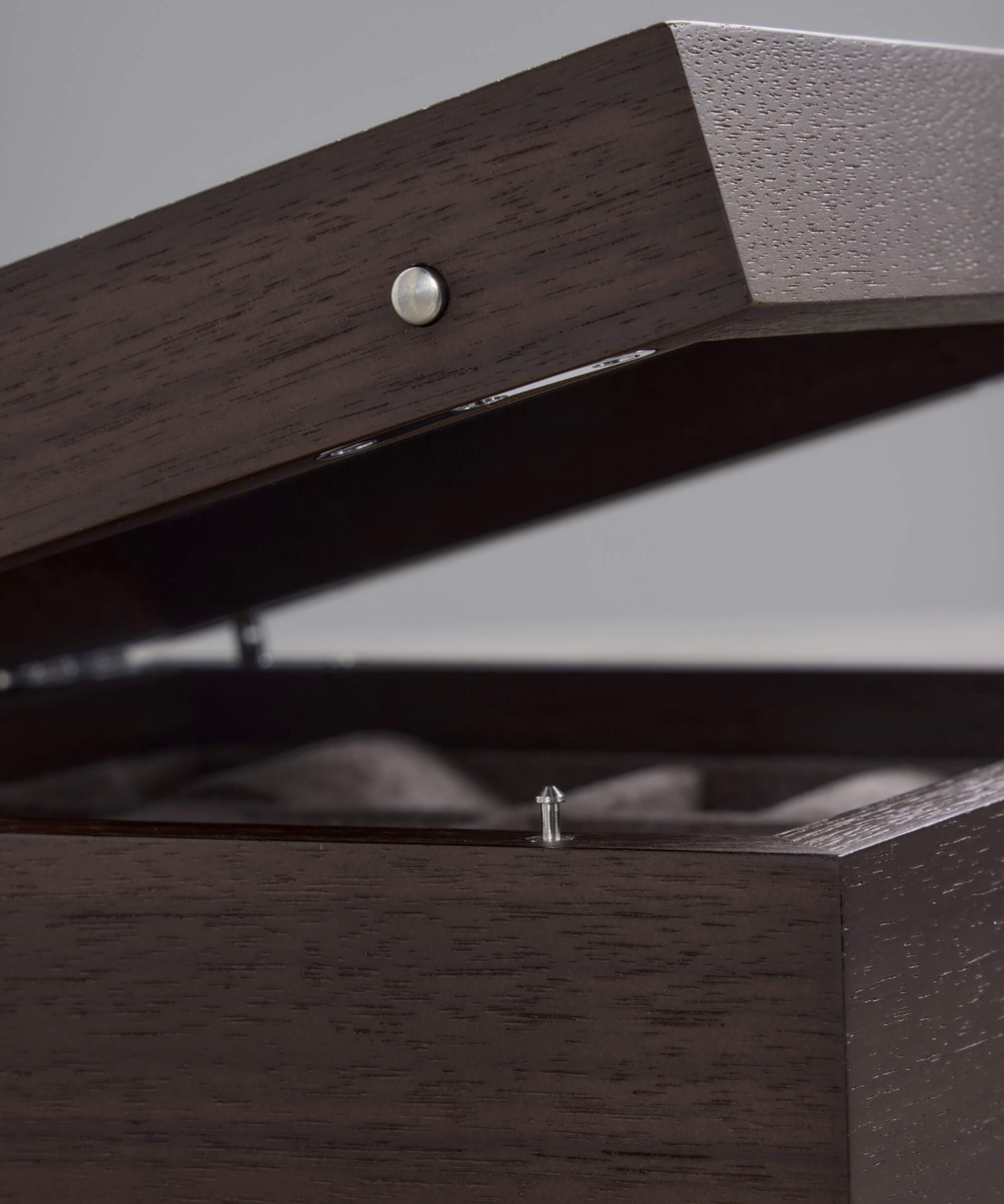 A close-up of the TAWBURY Grove 6 Slot Wooden Watch Box in dark walnut wood with a solid lid, partially open to show its soft interior and sleek metal clasp—ideal for storing elegant timepieces.