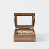 The TAWBURY Grove 6 Slot Wooden Watch Box in classic walnut features a glass lid and six compartments, shown open and empty on a white background.