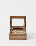 The TAWBURY Grove 6 Slot Wooden Watch Box in Light Walnut features a glass lid, beige interior, and six compartments—perfect for watch lovers. Shown open against a plain white background.