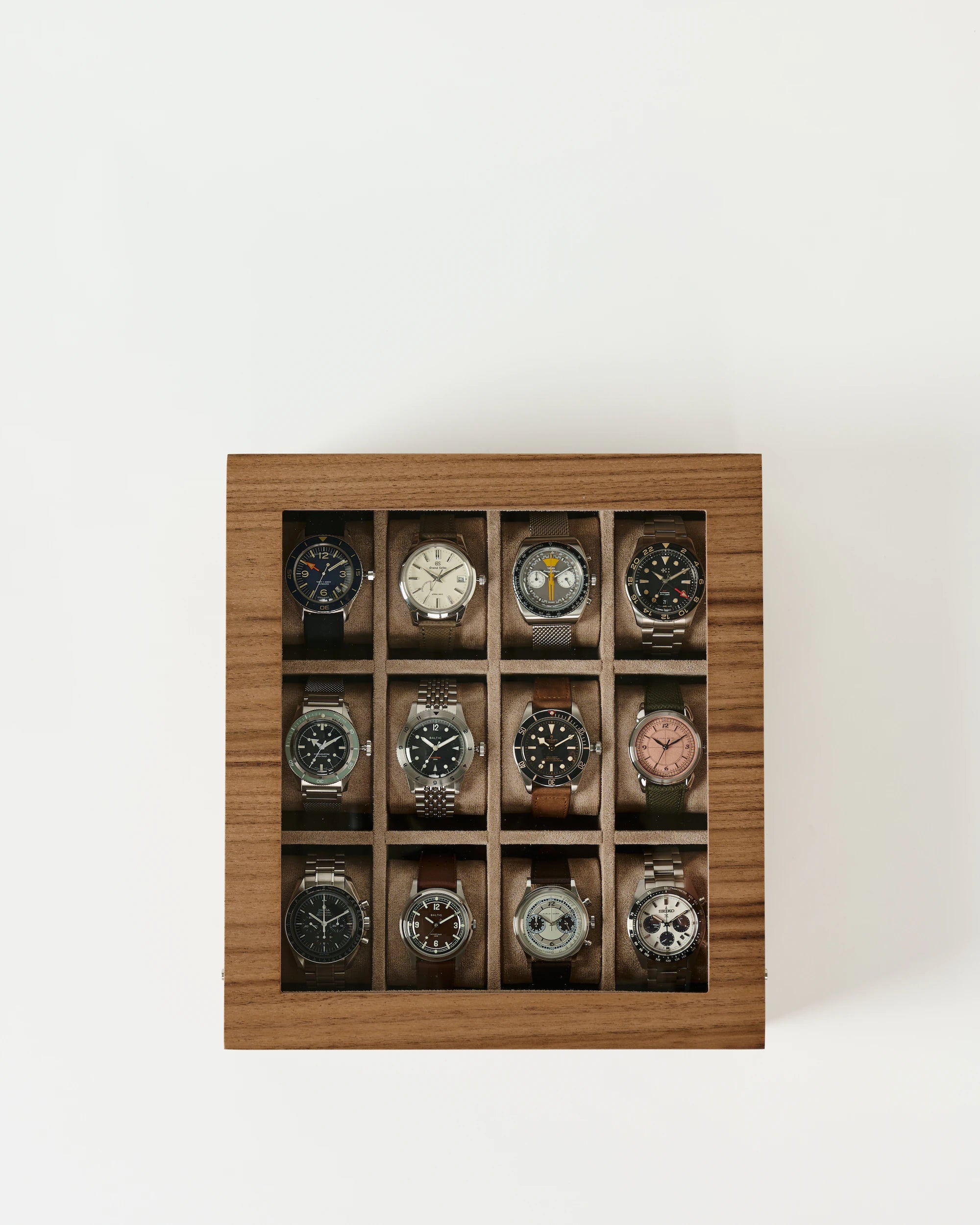 The TAWBURY Grove 12 Slot Wooden Watch Box in light walnut features a glass lid and twelve compartments, arranged in three rows of four, perfect for storing wristwatches.