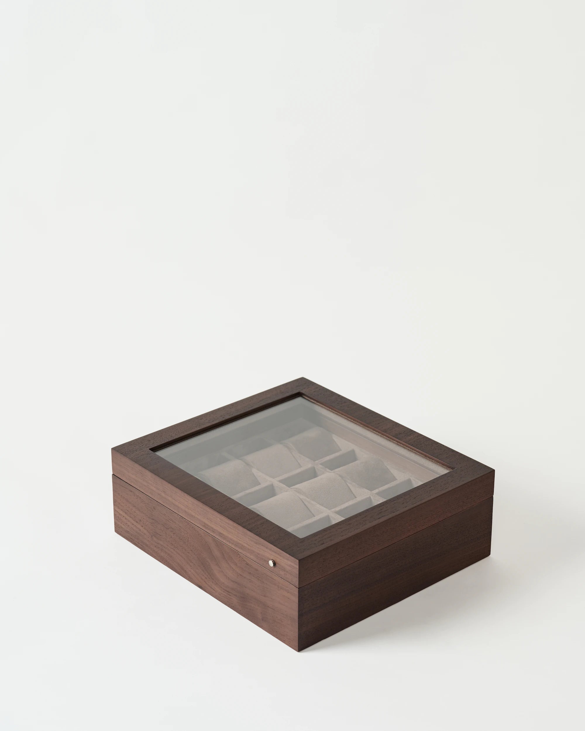 The TAWBURY Grove 12 Slot Wooden Watch Box in dark walnut wood features a glass lid, offering elegant storage and display for watches.