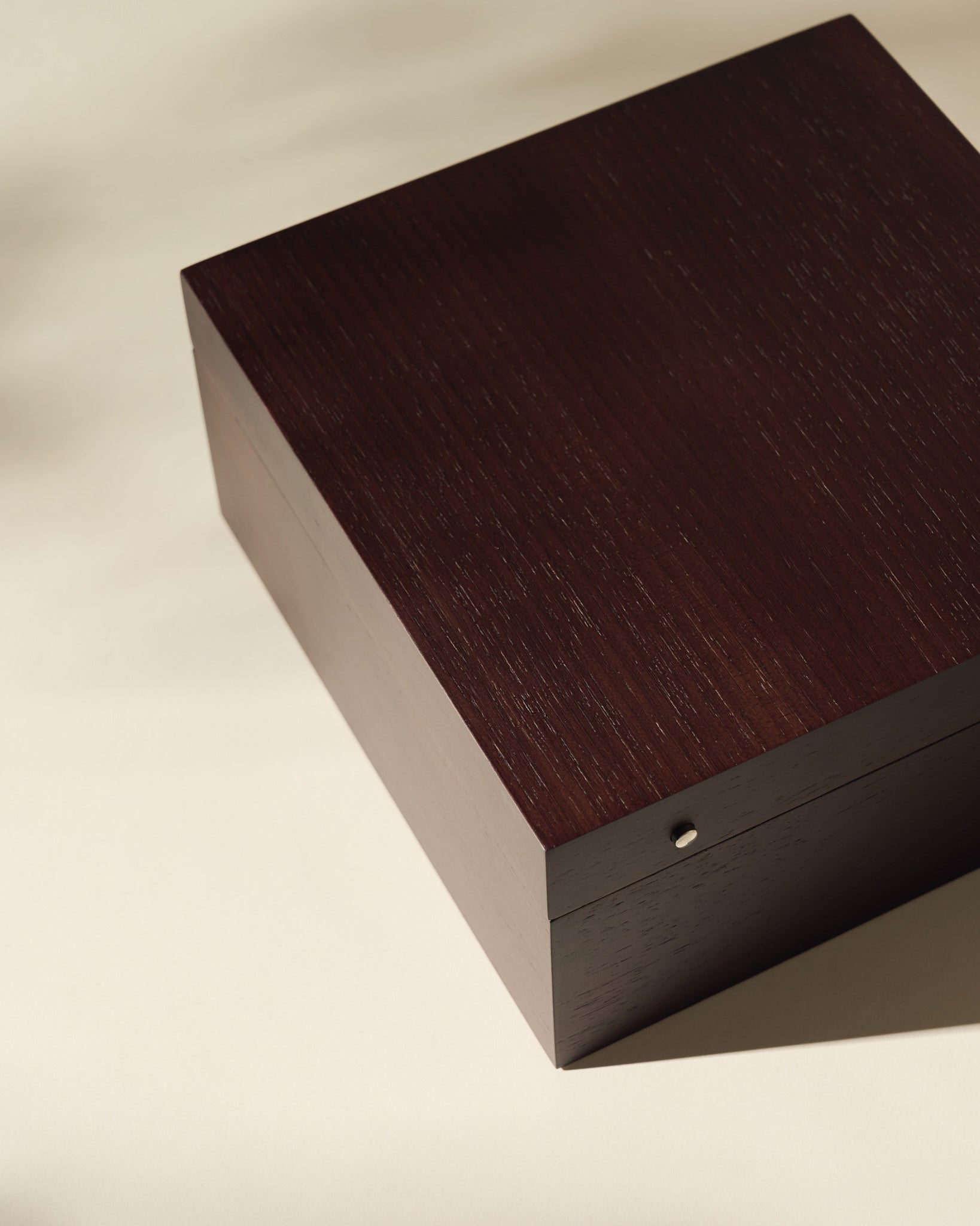 The TAWBURY Grove 6 Slot Wooden Watch Box, crafted from dark walnut wood with a solid lid, rests on a light surface and is photographed from above.