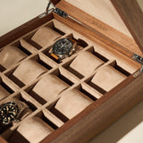 The TAWBURY Grove 12 Slot Wooden Watch Box in Light Walnut Wood features a solid lid and suede interior, stylishly holding two wristwatches with additional empty compartments for elegant storage.