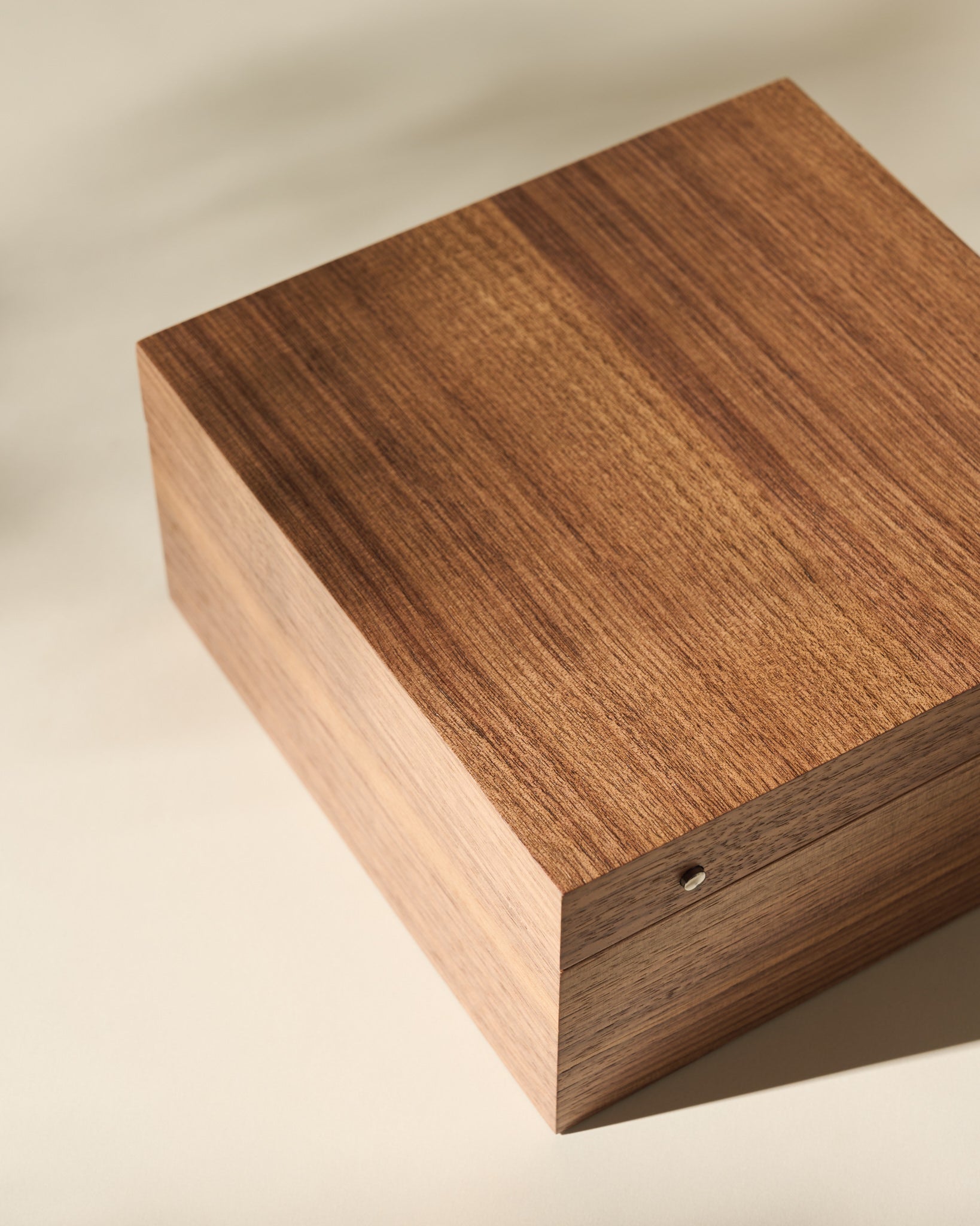 The TAWBURY Grove 6 Slot Wooden Watch Box in light walnut wood with a solid lid sits on a light surface, ideal for displaying and storing watches in style.