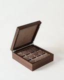 The TAWBURY Grove 12 Slot Wooden Watch Box in dark walnut features a solid lid and 12 cushioned slots, perfect for elegantly storing watches or organizing accessories.