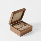 The TAWBURY Grove 6 Slot Wooden Watch Box in classic walnut wood features a closed lid and six cushioned compartments for storing watches or small accessories.
