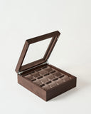 The TAWBURY Grove 12 Slot Wooden Watch Box in Dark Walnut Wood features a glass lid and cushioned compartments—ideal for stylishly storing and displaying your watch collection.