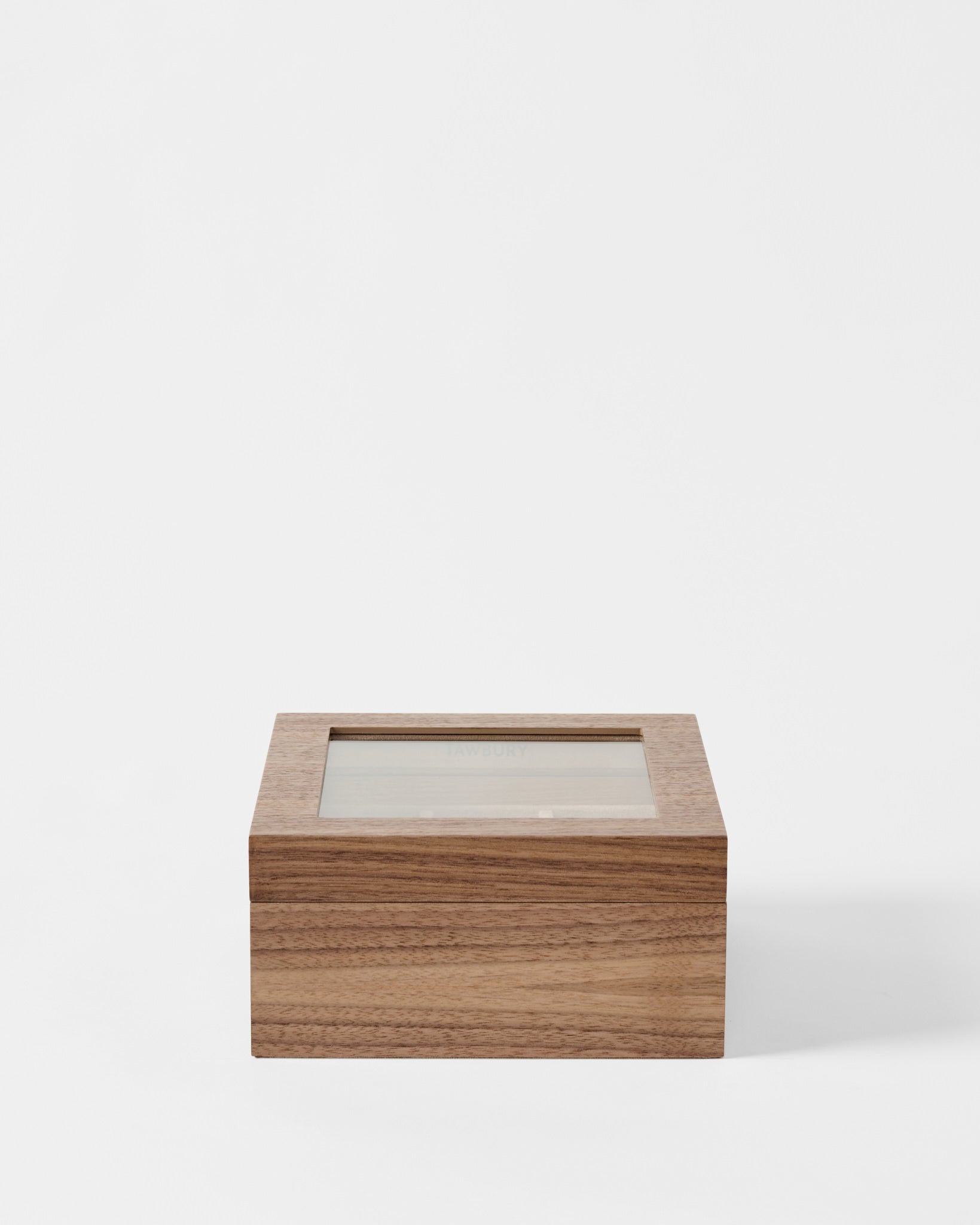 The TAWBURY Grove 6 Slot Wooden Watch Box in Light Walnut features a transparent glass lid, making it ideal for watch enthusiasts. Pictured against a plain white background.