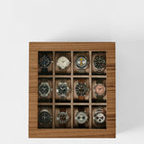 The TAWBURY Grove 12 Slot Wooden Watch Box in Light Walnut features a glass lid and individual compartments in a 3x4 grid, offering elegant storage and display for up to twelve wristwatches.