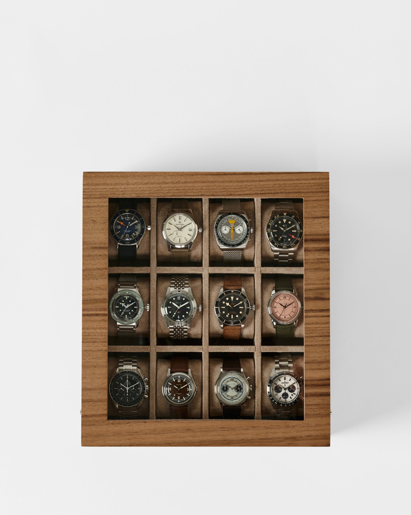 The TAWBURY Grove 12 Slot Wooden Watch Box in Light Walnut features a glass lid and individual compartments in a 3x4 grid, offering elegant storage and display for up to twelve wristwatches.