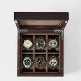 The TAWBURY Grove 6 Slot Wooden Watch Box in dark walnut features six compartments and a felt-lined interior, keeping your wristwatch collection organized and protected with its solid lid.