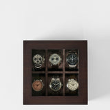 Showcase your watches in style with the TAWBURY Grove 6 Slot Wooden Watch Box. Crafted from dark walnut wood with a glass lid, it stores six wristwatches separately in two rows of three for elegant display and protection.